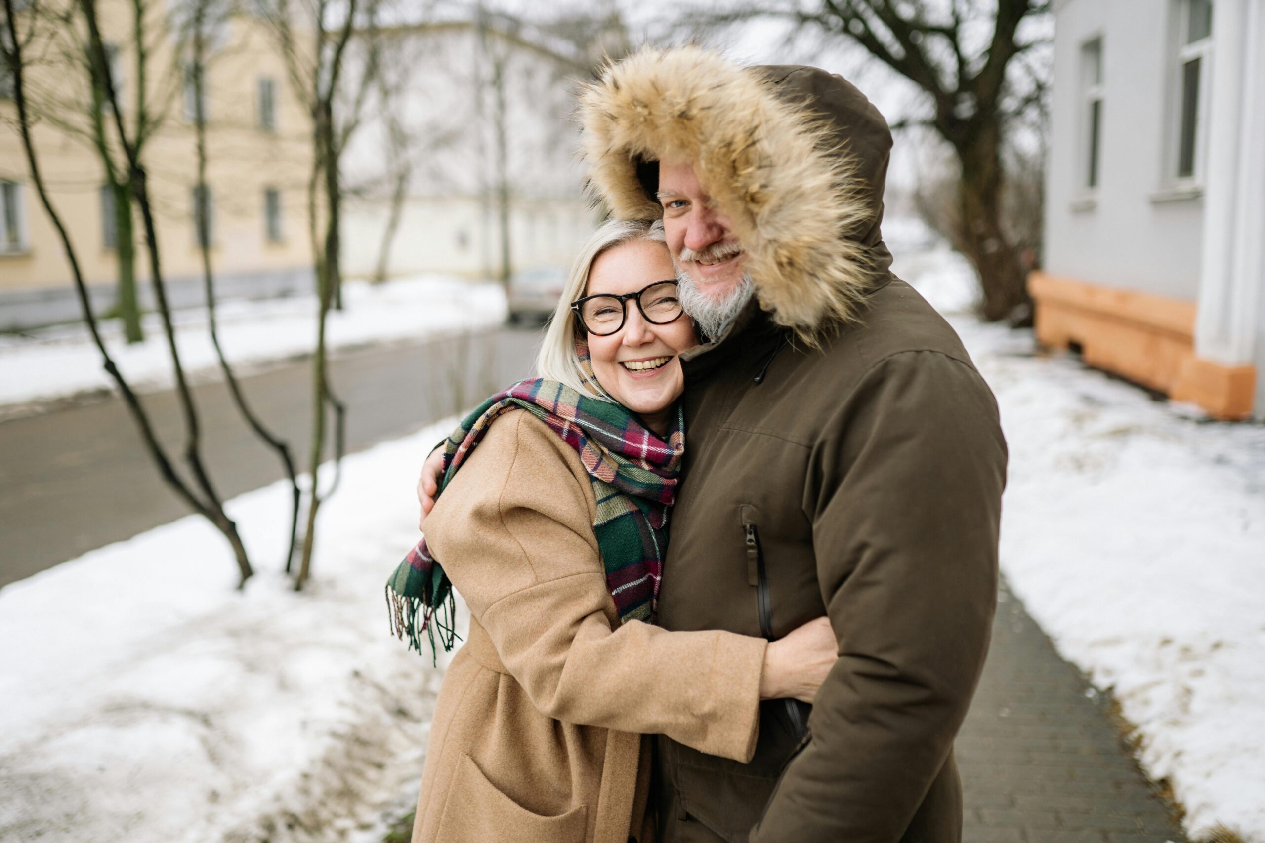 An elderly couple embracing in the snow An elderly couple embracing in the snow