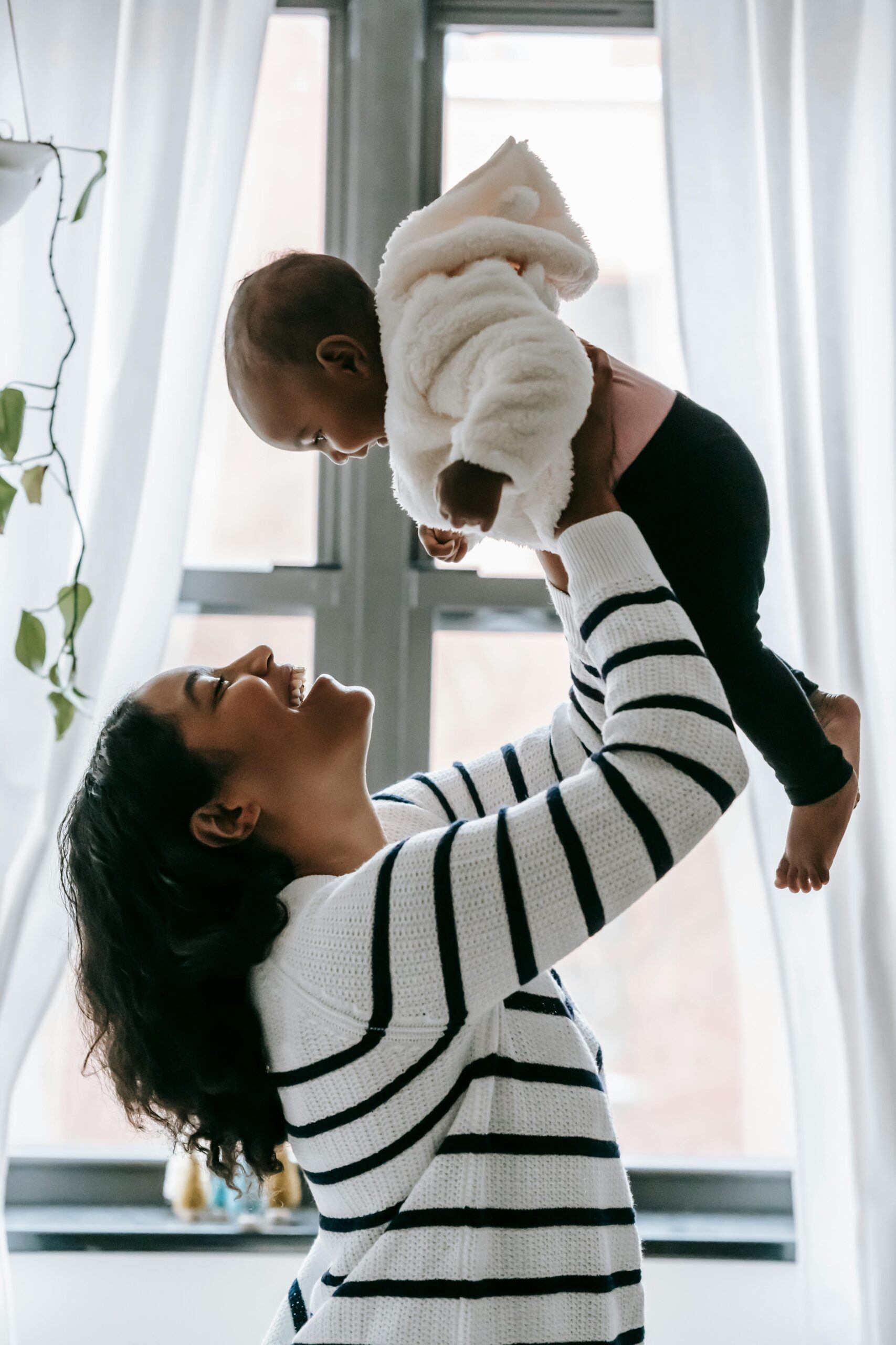 A mother holding her baby up high