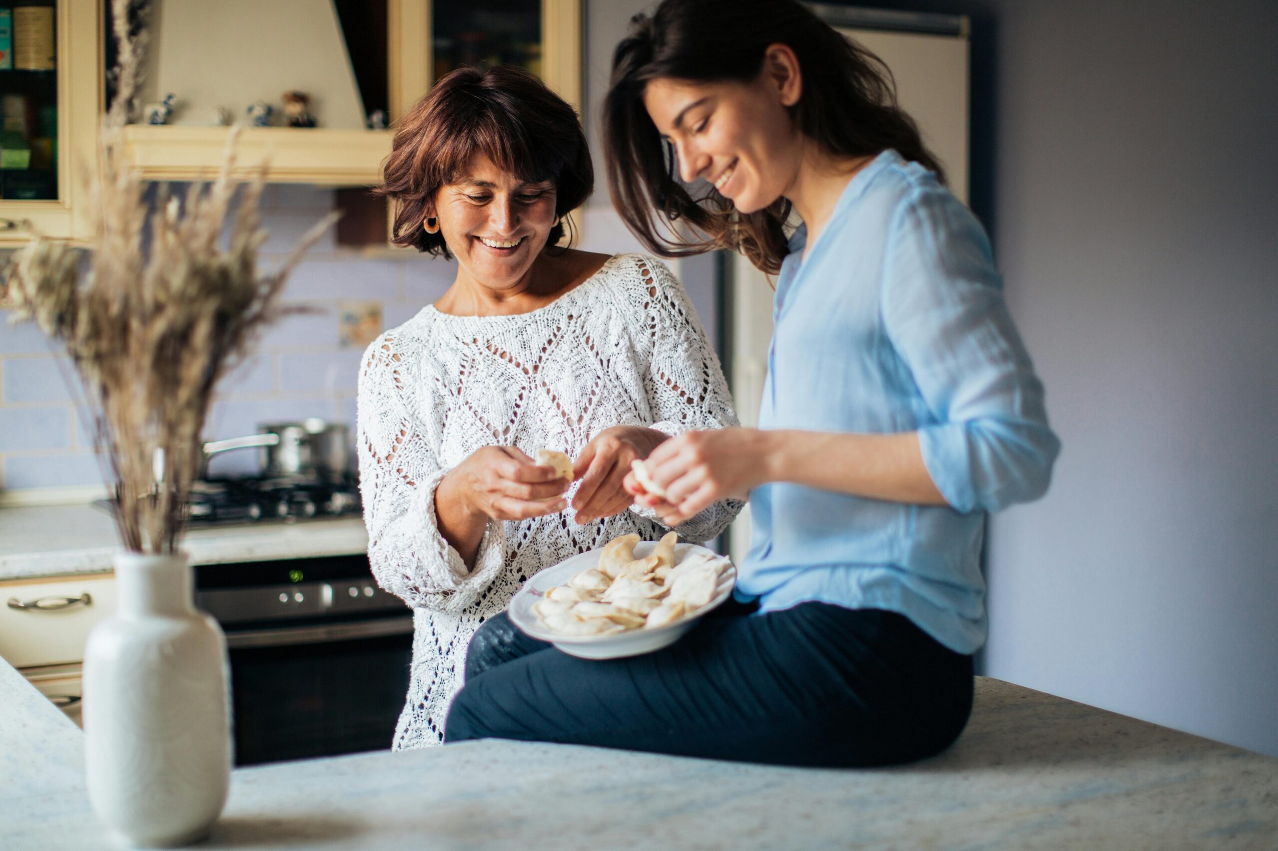 Two women in a kitchen having food Two women in a kitchen having food